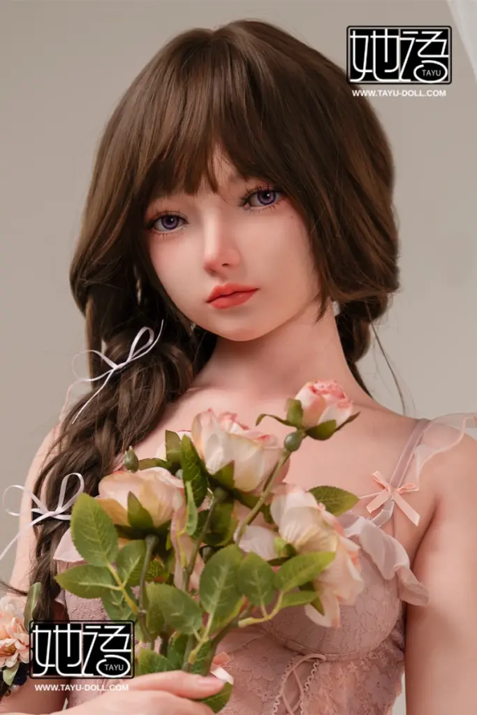TAYU Doll Chiori 160cm doll with brown braided hair, soft makeup, pink dress, stockings, and seated floral styling.
